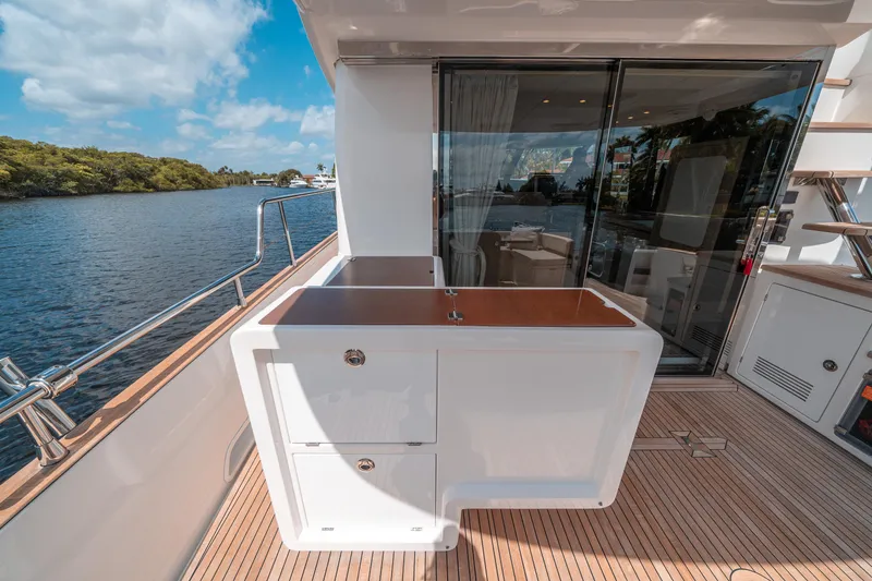 Slide: The Image of Azimut Magellano 53 yacht deck, 2018 model, featuring outdoor cabinetry and scenic water view. - 29