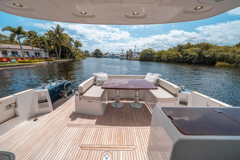 Slide: The Image of Azimut Magellano 53 yacht deck with seating, table, and scenic waterway view. - 30