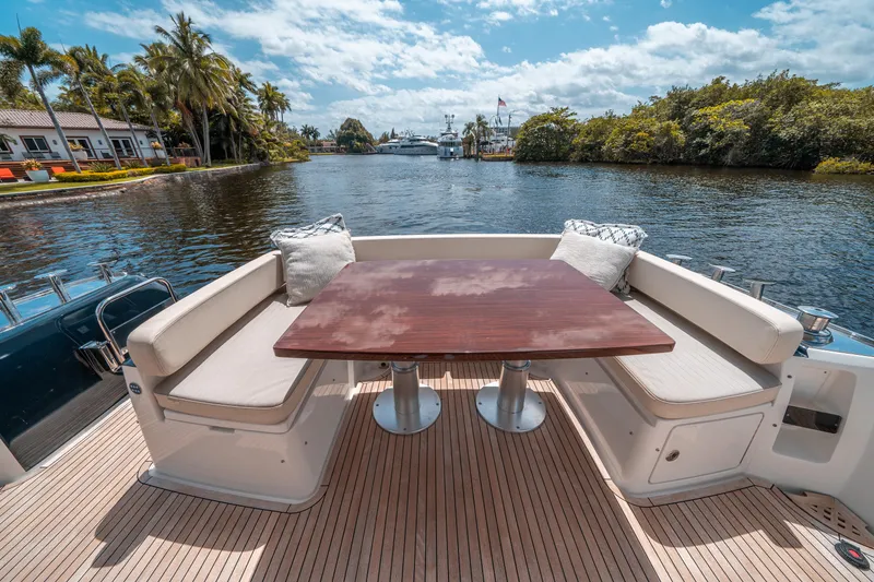 Slide: The Image of Azimut Magellano 53 yacht deck with seating and table, 2018 model, scenic waterway view. - 31