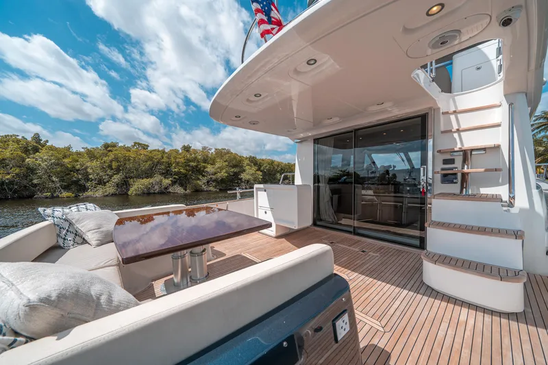 Slide: The Image of Luxurious 2018 Azimut Magellano 53 yacht deck with seating and table, under a clear sky. - 36