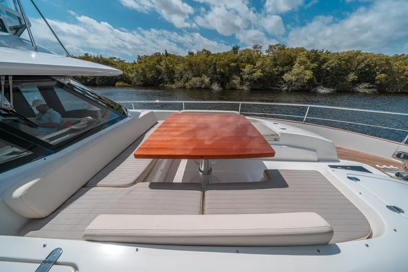Slide: The Image of Azimut Magellano 53 yacht deck with seating and table, 2018 model, scenic river view. - 43