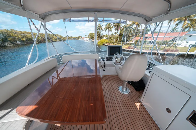 Slide: The Image of Azimut Magellano 53 yacht helm, featuring a sleek wooden table and modern navigation equipment. - 9