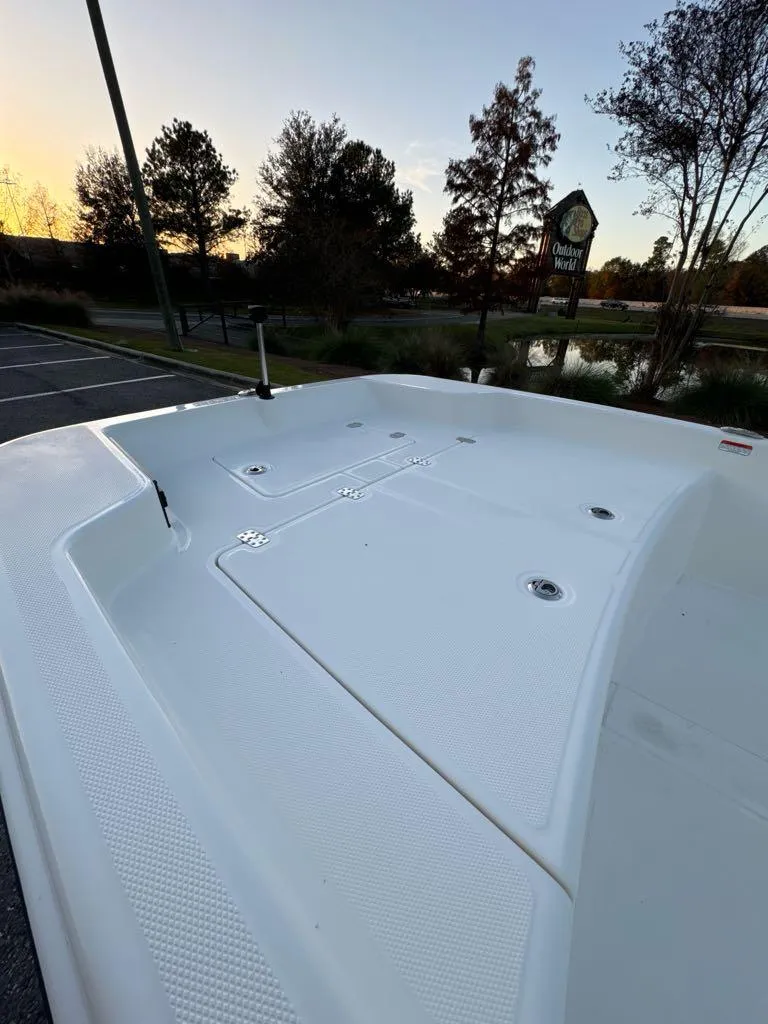 Slide: The Image of 2025 Mako Pro Skiff 15 CC boat deck at sunset, surrounded by trees and water. - 4