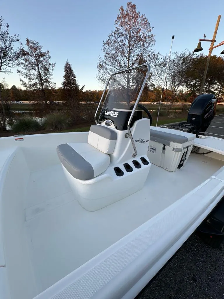 Slide: The Image of 2025 Mako Pro Skiff 15 CC boat with center console and seating, parked outdoors. - 5