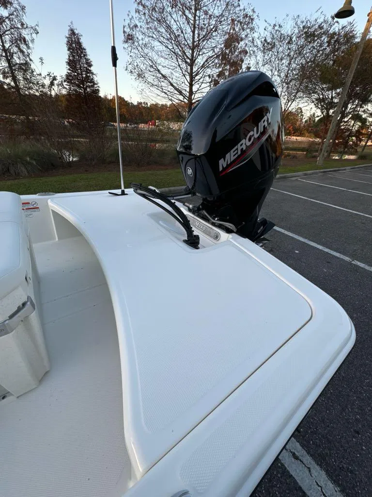 Slide: The Image of 2025 Mako Pro Skiff 15 CC with Mercury outboard motor in a parking lot. - 6