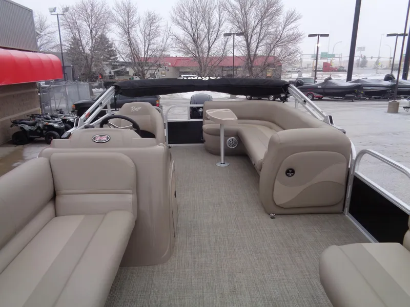 Slide: The Image of 2023 Ranger Reata 200C pontoon boat with beige seating and spacious deck. - 2