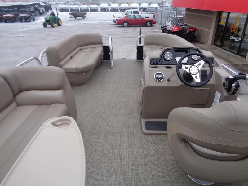 Slide: The Image of 2023 Ranger Reata 200C pontoon boat interior with beige seating and steering console. - 3