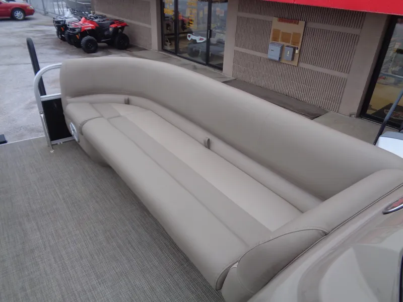 Slide: The Image of 2023 Ranger Reata 200C boat with beige seating, parked near a building. - 43