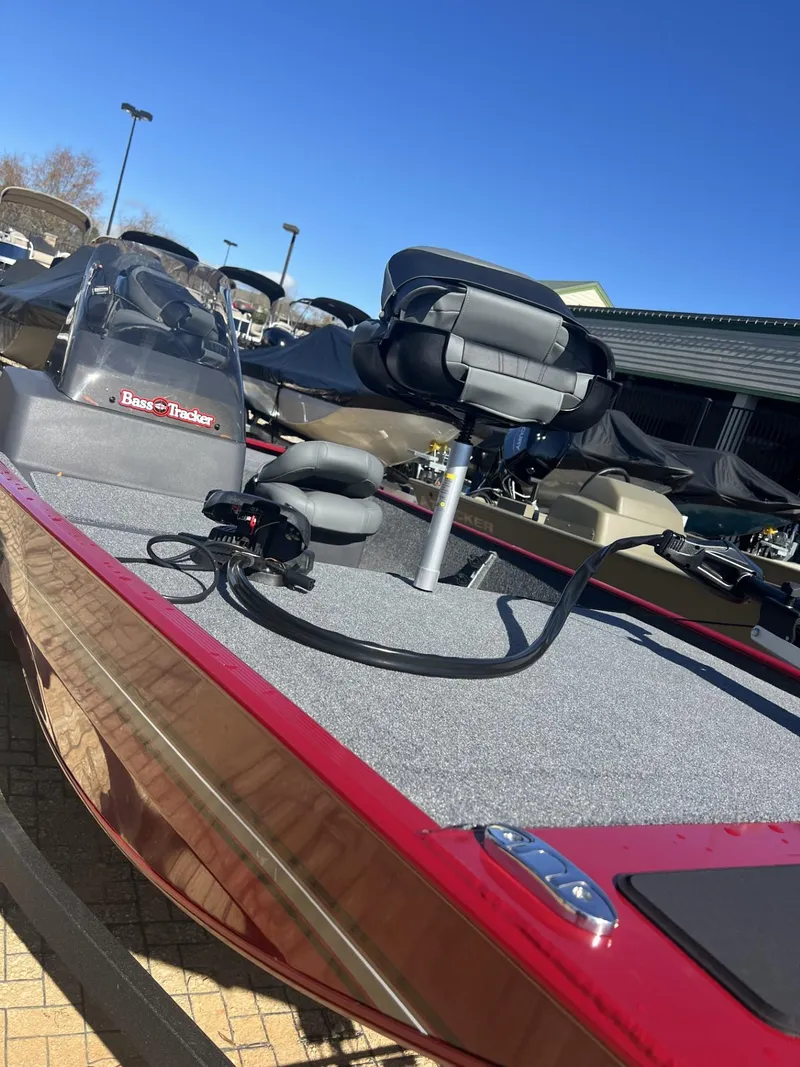 Slide: The Image of 2025 Tracker Bass Tracker Classic XL boat with red exterior and fishing seat. - 2