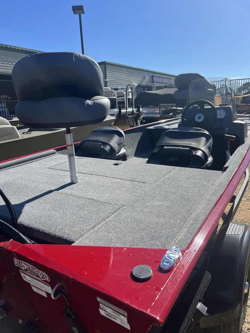Slide: The Image of 2025 Tracker Bass Tracker Classic XL boat with seating and steering console, parked outdoors. - 4