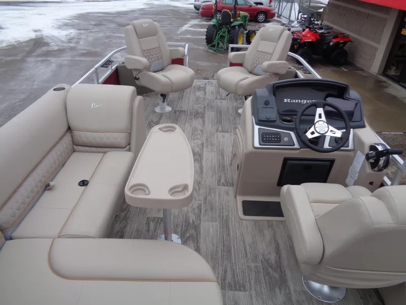 Slide: The Image of 2024 Ranger Reata 220F pontoon boat interior with beige seating and steering console. - 16