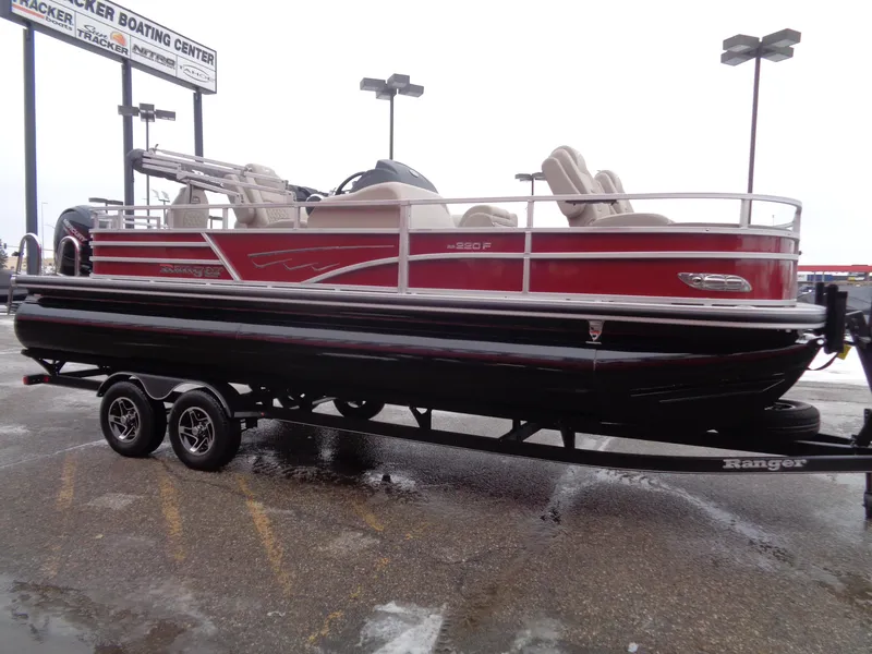 Slide: The Image of 2024 Ranger Reata 220F pontoon boat on trailer in parking lot. - 3