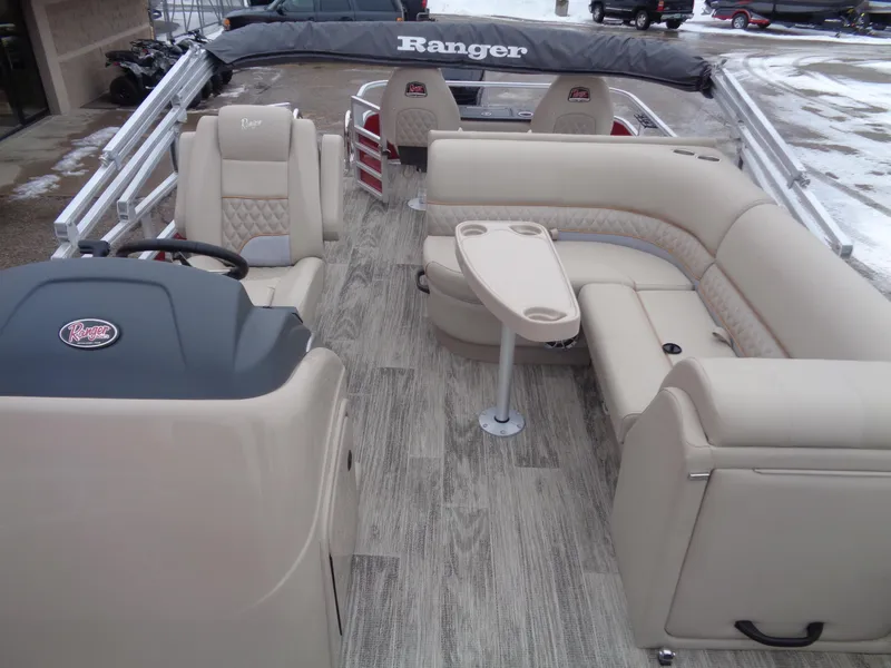 Slide: The Image of 2024 Ranger Reata 220F pontoon boat interior with beige seating and wood-style flooring. - 8