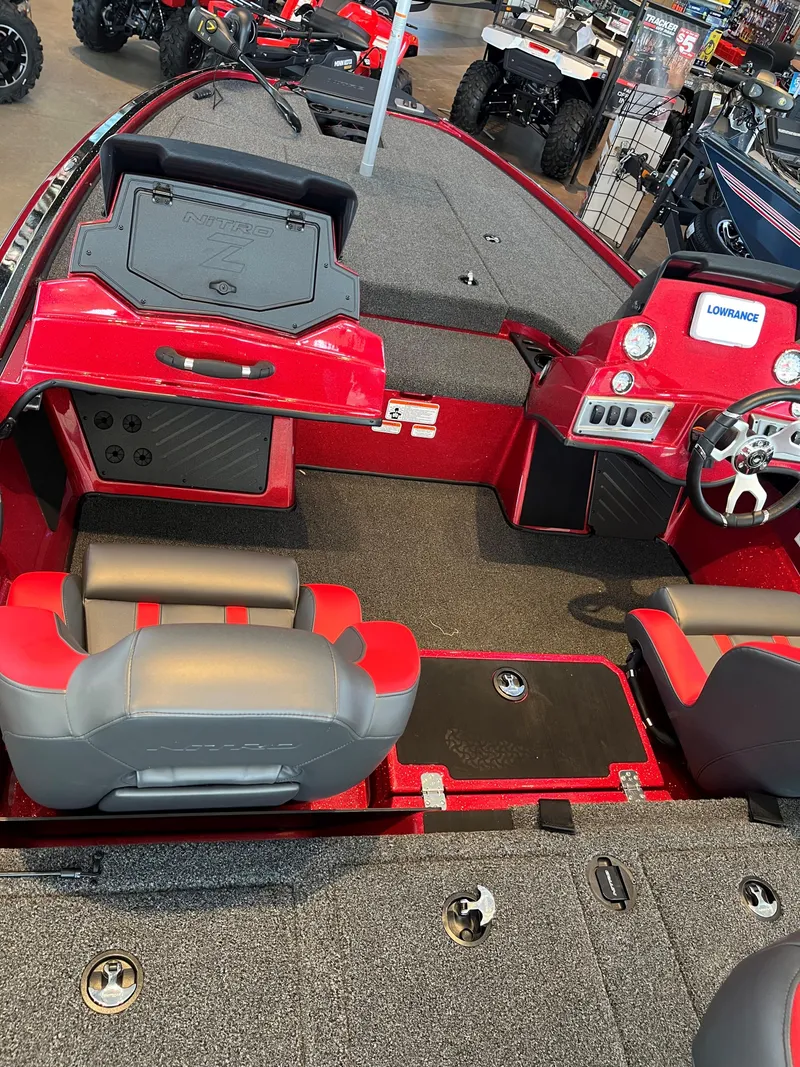 Slide: The Image of 2025 Nitro Z19 boat interior with red and gray seating, steering console, and storage compartments. - 1