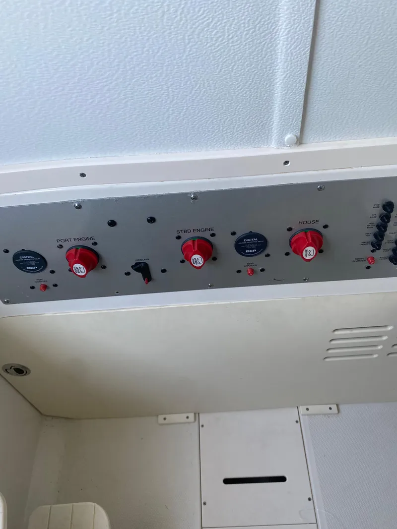 Slide: The Image of 2017 Hydra-Sports 3400 Center Console control panel with red switches and dials. - 17