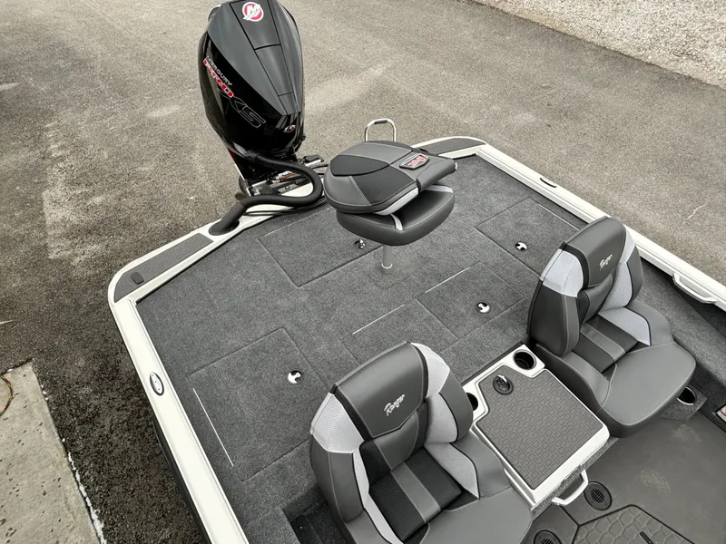 Slide: The Image of 2025 Ranger ALPHA 208 boat interior with seating and motor, on a paved surface. - 14