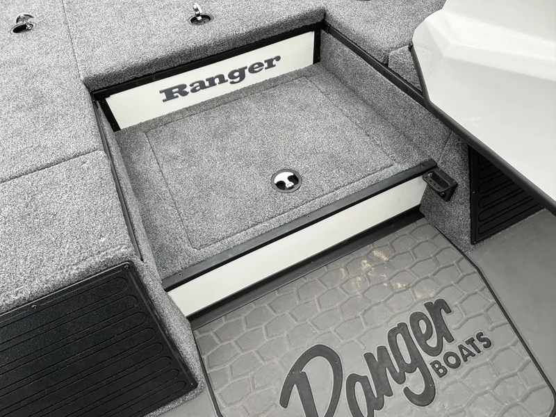 Slide: The Image of Ranger ALPHA 208 boat interior, 2025 model, featuring storage compartment and branded flooring. - 6