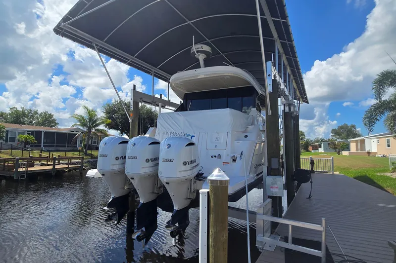 Slide: The Image of 2020 Regal 38 XO boat with triple Yamaha 300 engines on a lift, under a canopy. - 3