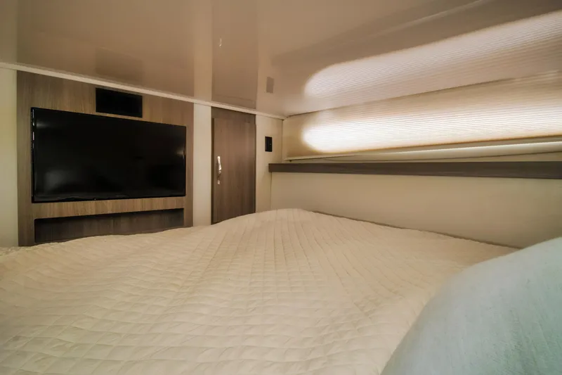 Slide: The Image of Luxurious interior cabin of 2020 Regal 38 XO yacht with TV and cozy bedding. - 32