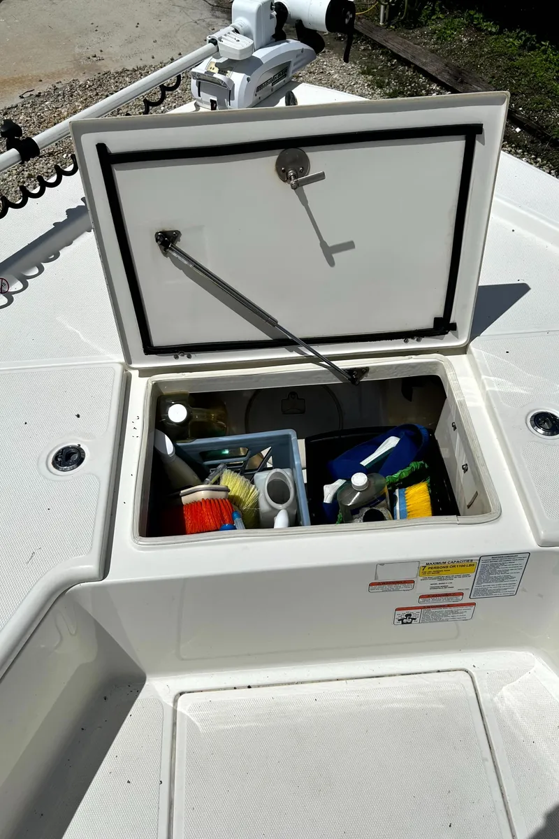 Slide: The Image of Open storage compartment on 2018 Mako 21LTS boat with cleaning supplies. - 11