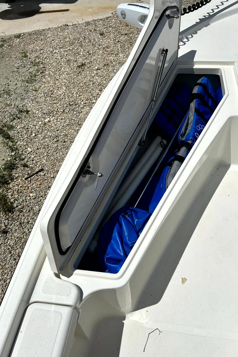 Slide: The Image of Open storage compartment on 2018 Mako 21LTS boat, showing interior space. - 13