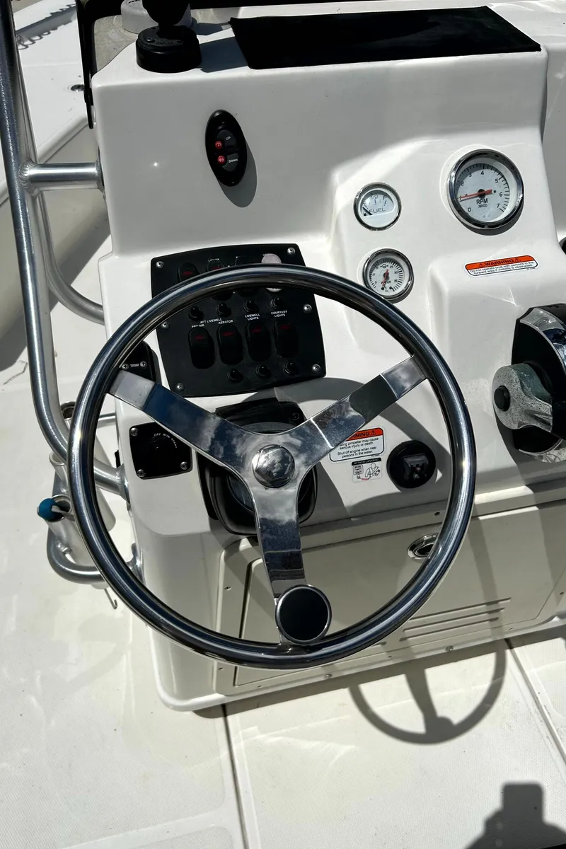 Slide: The Image of 2018 Mako 21LTS boat steering console with gauges and controls. - 8