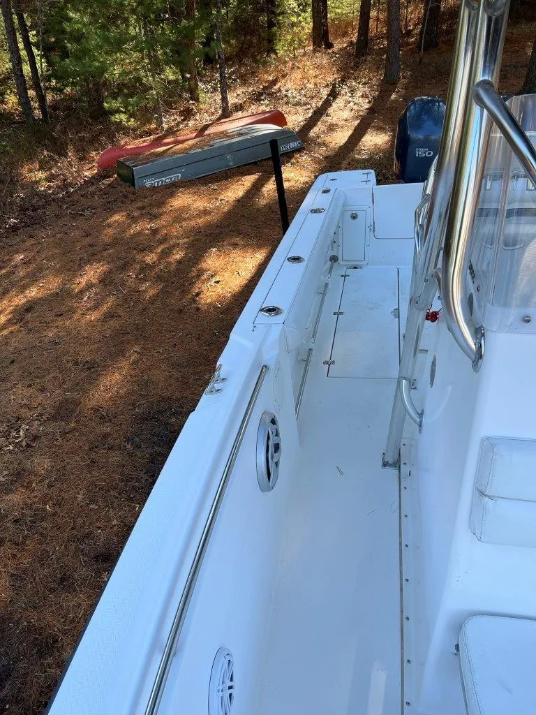 Slide: The Image of 2006 Edgewater 245CC boat on dry land, surrounded by trees. - 11