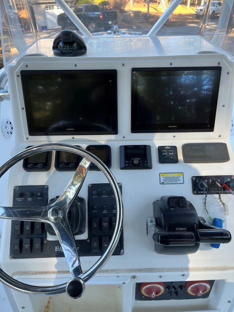 Slide: The Image of Edgewater 245CC 2006 boat dashboard with dual screens and steering wheel. - 7