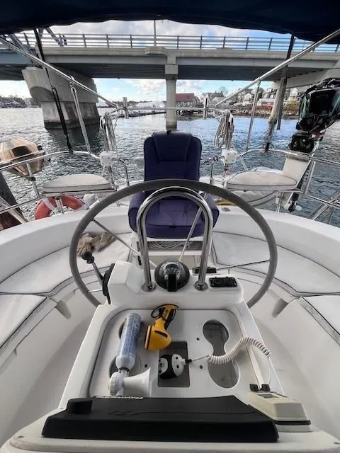Slide: The Image of Steering wheel of 2001 Hunter 401 sailboat docked under a bridge. - 15
