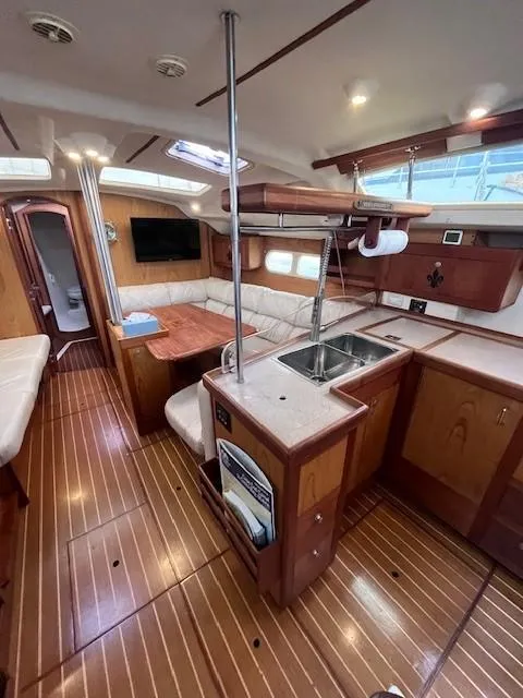 Slide: The Image of Interior of 2001 Hunter 401 sailboat with wood flooring and cozy seating area. - 23