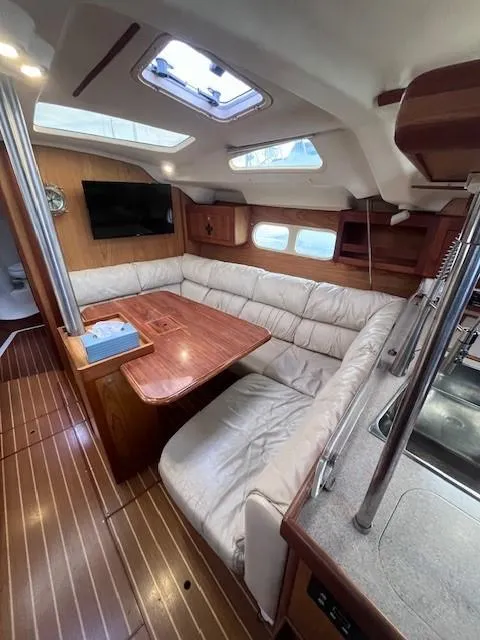 Slide: The Image of Interior of 2001 Hunter 401 sailboat with wood flooring and cozy seating area. - 24