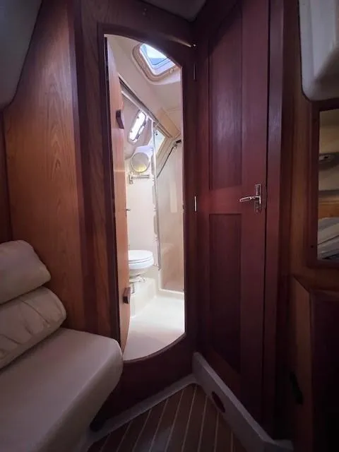 Slide: The Image of Interior of 2001 Hunter 401 yacht, featuring wooden cabinetry and compact bathroom. - 44