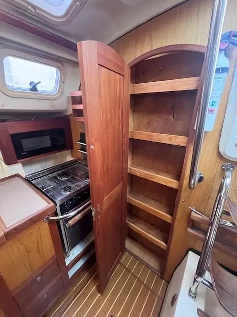 Slide: The Image of 2001 Hunter 401 yacht kitchen with wooden cabinets and stove. - 48