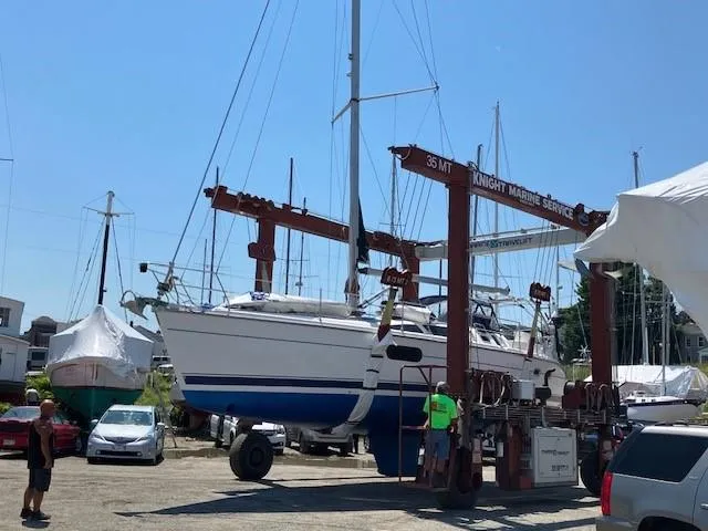 Slide: The Image of Hunter 401 sailboat from 2001 being lifted at a marina service area. - 5