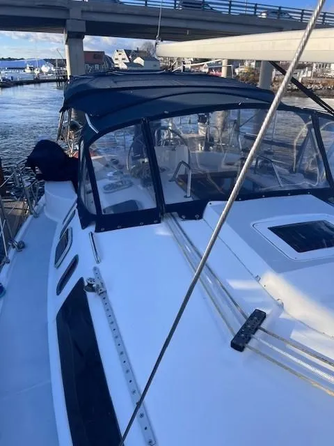 Slide: The Image of 2001 Hunter 401 sailboat docked under a bridge, featuring a sleek design and blue canopy. - 7