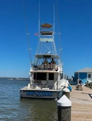 Slide: The Image of 1990 Viking Convertible yacht docked at a marina under clear blue skies. - 40