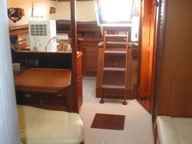 Slide: The Image of Interior of 1997 Island Packet 40 sailboat with wooden furnishings and compact layout. - 11