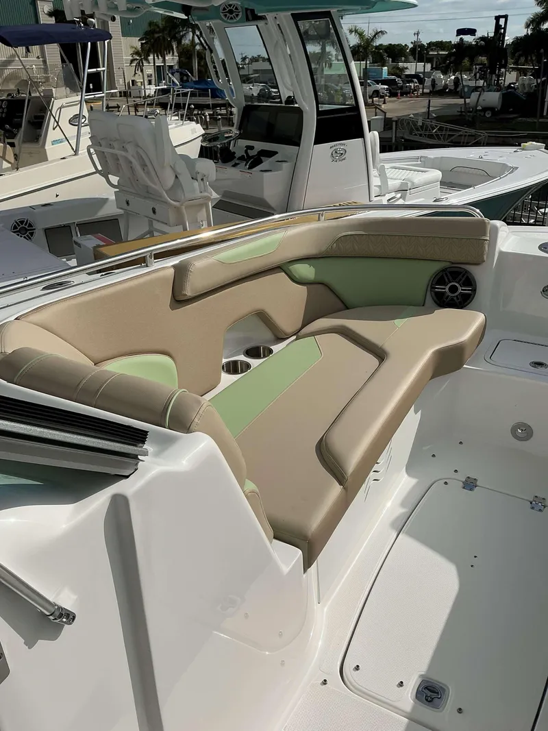 Slide: The Image of 2025 Hurricane 2400 SD boat interior with beige and green seating. - 14