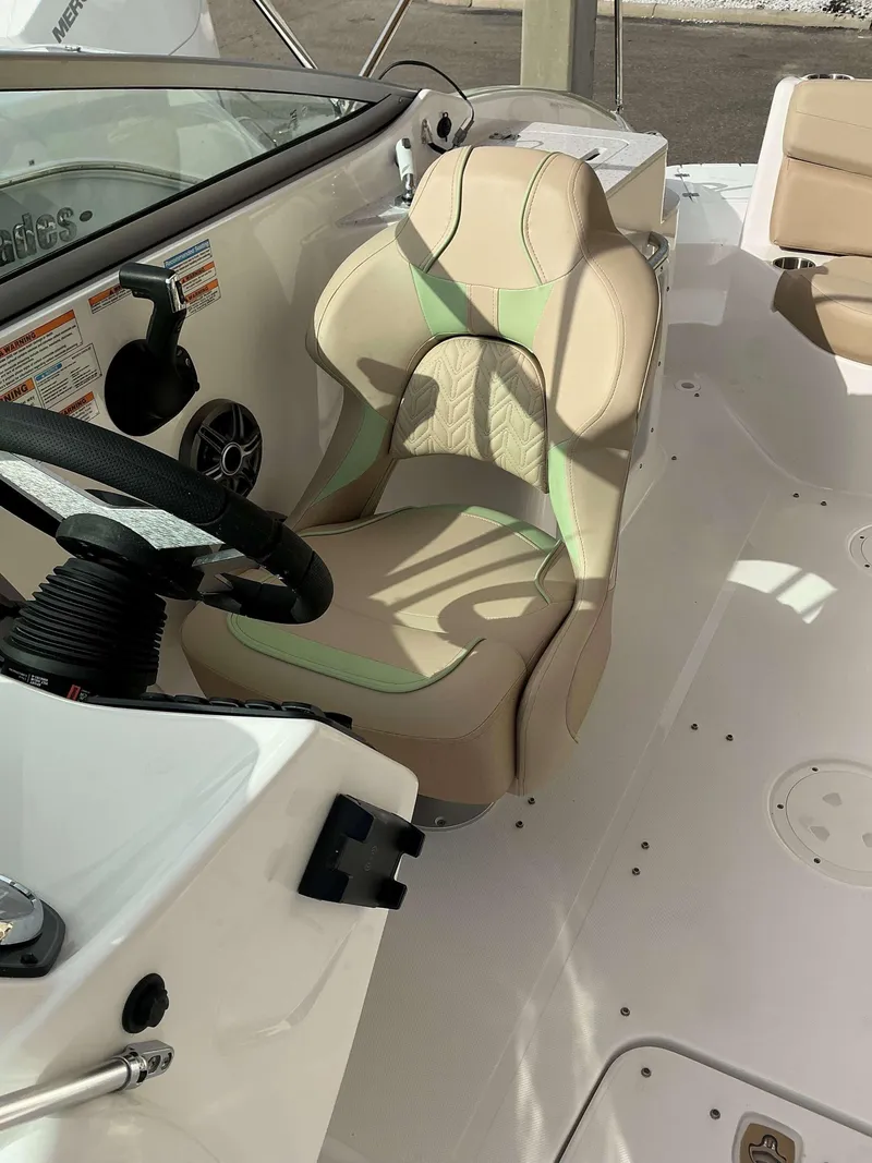 Slide: The Image of 2025 Hurricane 2400 SD boat interior with beige and green captain's seat. - 3