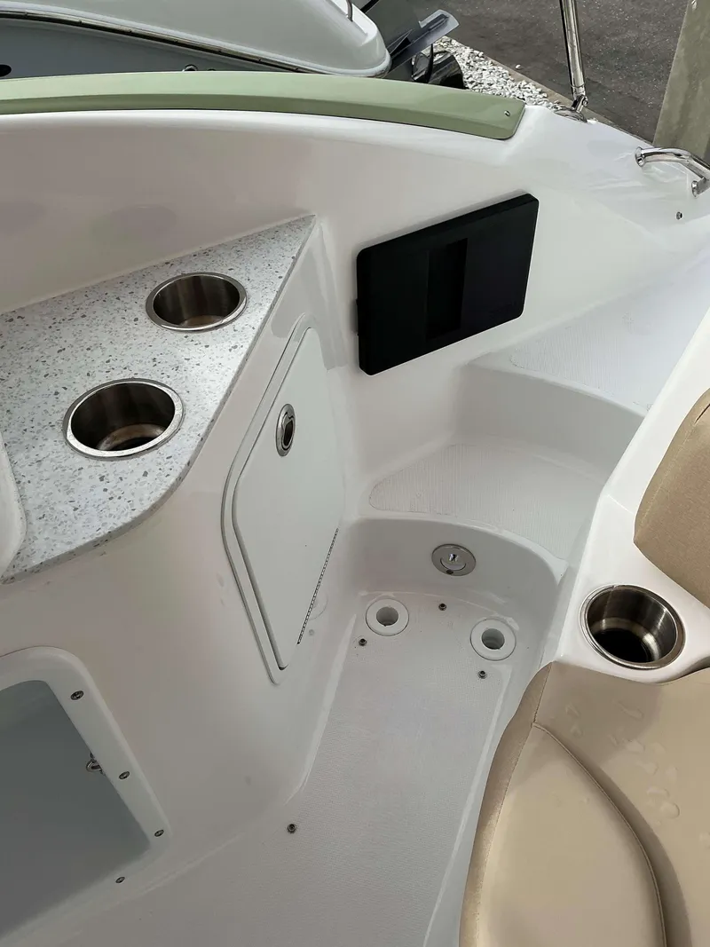 Slide: The Image of 2025 Hurricane 2400 SD boat interior with cup holders and storage compartment. - 7