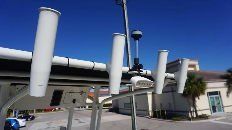 Slide: The Image of 2019 Stingray 216 CC boat with rod holders and equipment against a clear blue sky. - 16