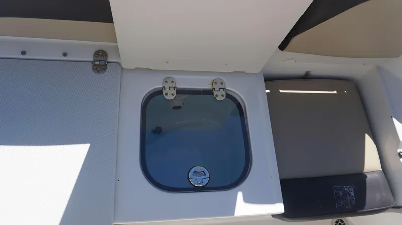 Slide: The Image of 2019 Stingray 216 CC boat storage compartment with open lid. - 19