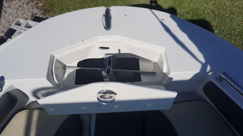 Slide: The Image of 2019 Stingray 216 CC boat anchor compartment, open lid, sunny day. - 7