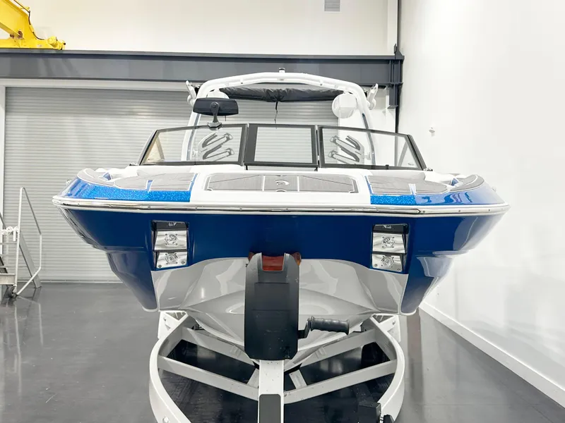 Slide: The Image of 2025 Centurion Fe23 boat in showroom, front view, blue and white design. - 4