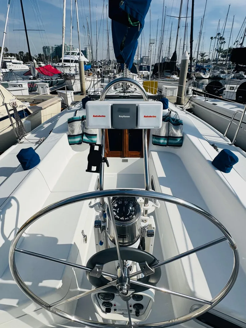 Slide: The Image of 1998 Catalina 320 sailboat cockpit with steering wheel, docked in marina. - 10