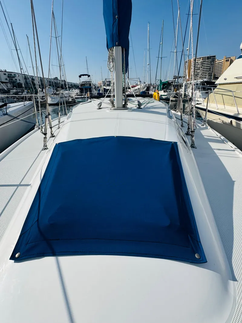 Slide: The Image of 1998 Catalina 320 sailboat deck with blue cover in marina. - 11