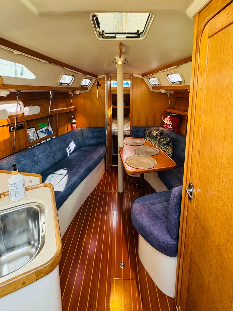 Slide: The Image of 1998 Catalina 320 yacht interior with wood finish and blue seating. - 16
