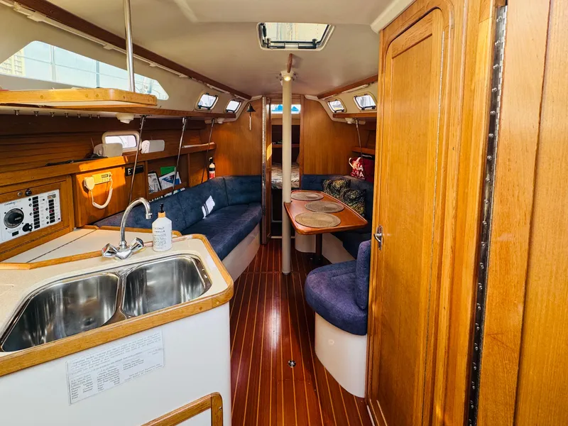 Slide: The Image of Interior of 1998 Catalina 320 sailboat with wood finish and cozy seating area. - 17
