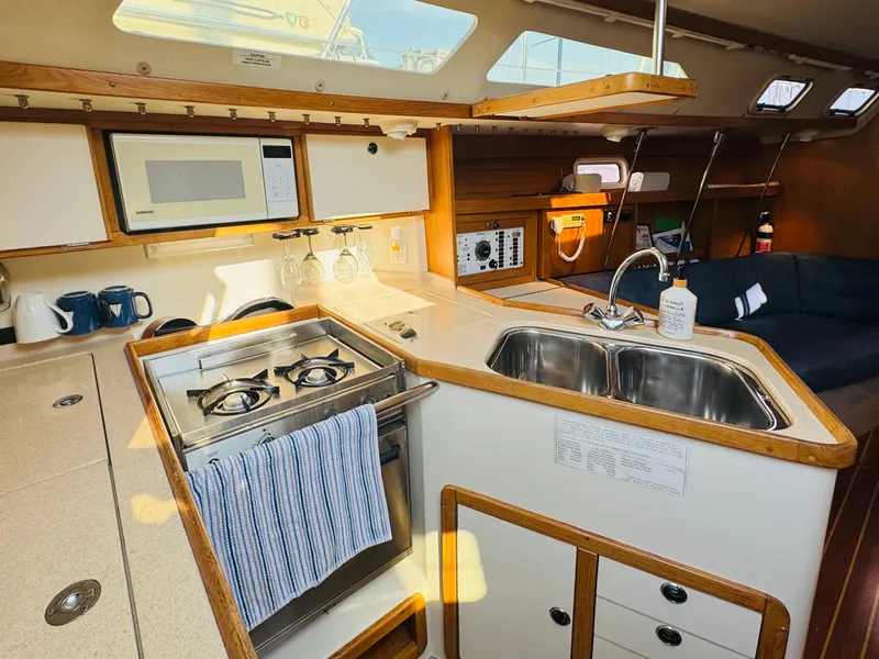 Slide: The Image of Interior of 1998 Catalina 320 sailboat kitchen with stove, sink, and microwave. - 18