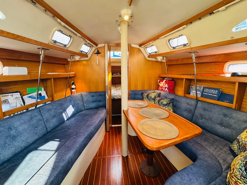 Slide: The Image of Interior of 1998 Catalina 320 sailboat with cozy seating and wooden accents. - 20